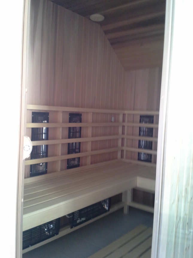Interiér domácí infrasauny na míru z červeného cedru. Výroba sauny s umístěním v podkroví domu pod šikmou střechu